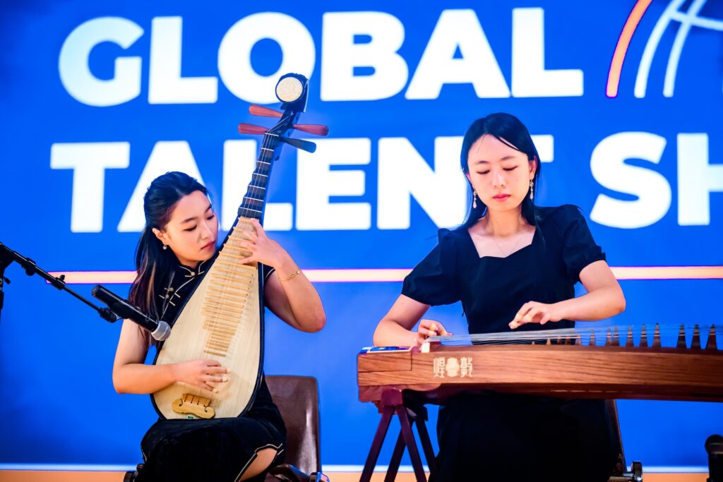 Two students performing with traditional string instruments from China